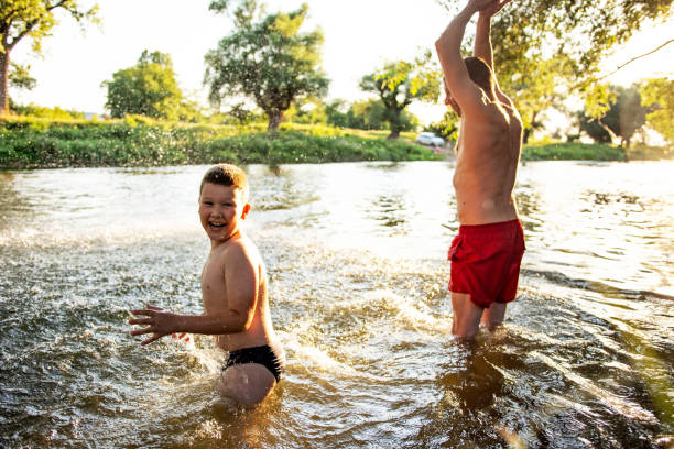 istock Father and son having fun at river on sunny summer day 1410804546