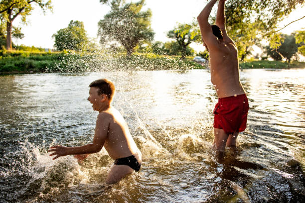 istock Father and son having fun at river on sunny summer day 1410804547