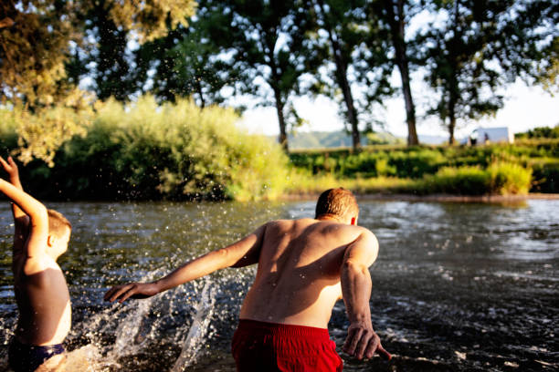 istock Father and son having fun at river on sunny summer day 1410804599