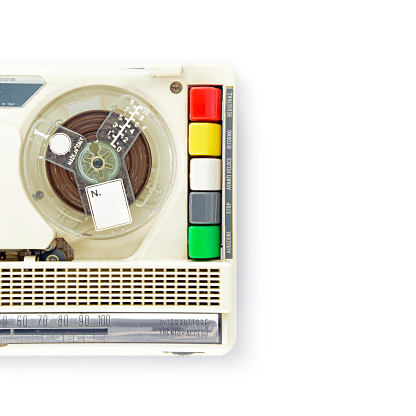 Vision from above on white background of the tape reel and the playing buttons for this '60 Italian recorder. Brands removed.
