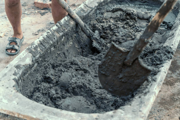 istock Workers stir or mix cement with shovels at construction site 1410805174