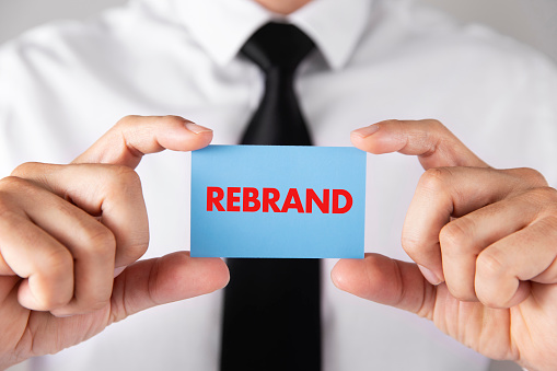 Businessman shows business card with the word rebrand