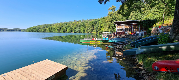Germany Feldberg - July 17. 2022 - Around the popular health resort Feldberg in Mecklenburg Vorpommern there are several lakes that invite for canoeing or hiking. The so-called Schmale Luzin is crossed by a ferry so that hikers can walk around the lake.