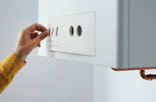 istock Woman checking settings on the boiler 1410816011