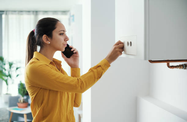 ボイラー故障サービスを呼ぶ女性 - plumber thermostat repairing engineer ストックフォトと画像