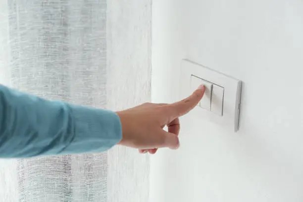 Photo of Woman pressing a light switch