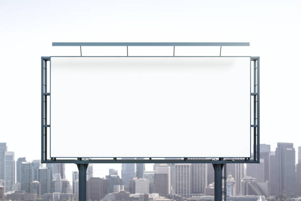 Blank white billboard on city buildings background at daytime, front view. Mockup, advertising concept stock photo