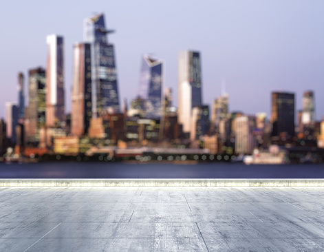 Empty concrete dirty embankment on the background of a beautiful blurry New York city skyline at night, mockup