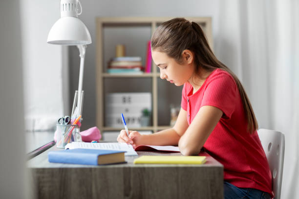 istock student girl with book writing to notebook at home 1410822732