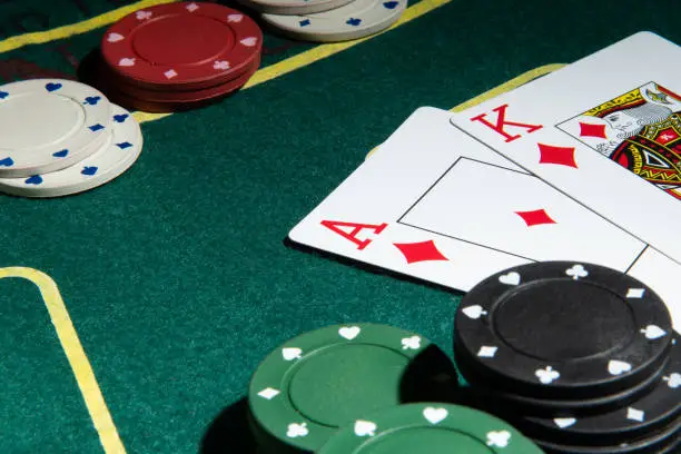 Photo of Poker cards on a playing green table with chips.