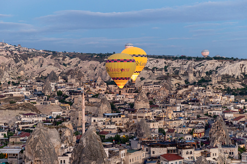 GOREME/TURKEY - June 29, 2022: hot air balloons fly low over the city of goreme.