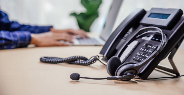 istock Communication support, call center and customer service help desk. telephone devices with VOIP headset in office.Customer service support (call center) concept. 1410824811