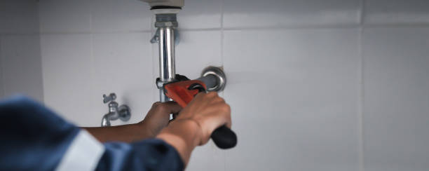 Male Plumber Using Wrench To Fix Leaking Sink In Home Bathroom. Male Plumber Using Wrench To Fix Leaking Sink In Home Bathroom. plumb line stock pictures, royalty-free photos & images