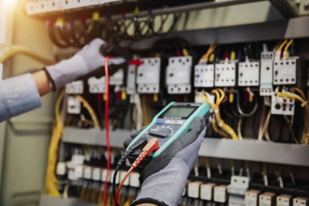 istock Electricity and electrical maintenance service, Engineer hand holding AC multimeter checking electric current voltage at circuit breaker terminal and cable wiring main power distribution board. 1410825130