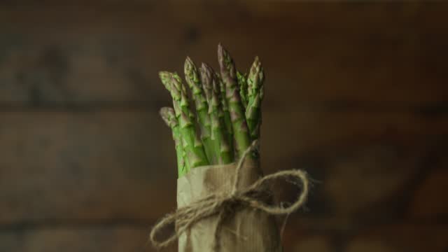 asparagus bunch tied with rope, spinning from dark to light
