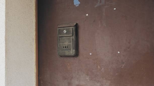 istock Simple Cheap Old Fashioned Flat Metal Letterbox Hanging on Door 1410826561