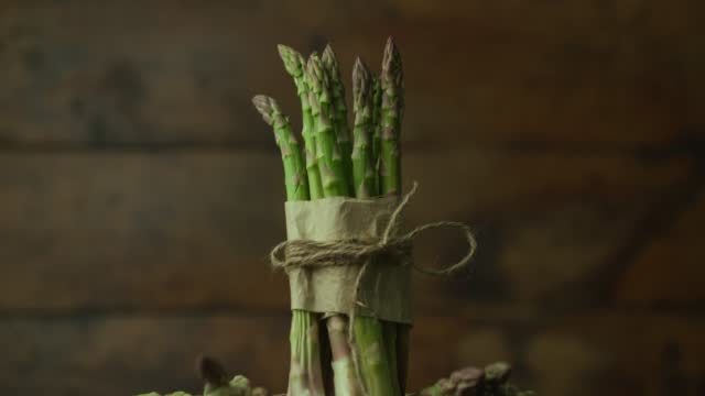 the perfect vegetable for vegans, fresh asparagus on top of wooden table tied with rope