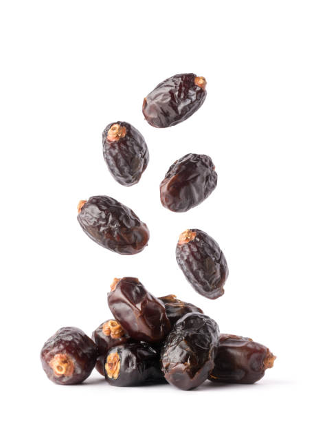 dates falling on white background fresh dates falling isolated on white background, edible and tropical sweet fruits, closeup date palm tree stock pictures, royalty-free photos & images