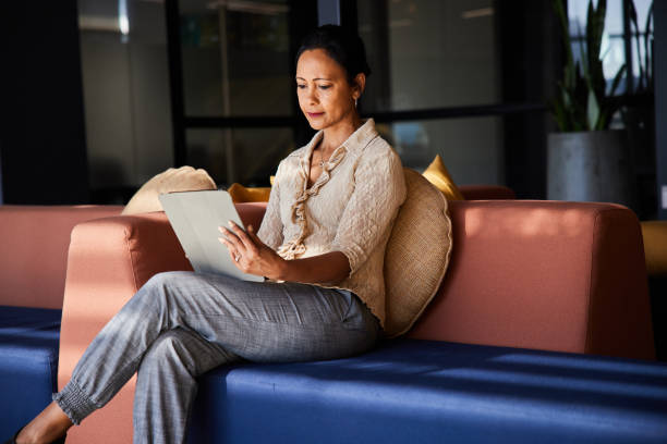 istock Focused mature businesswoman working on a tablet on an office sofa 1410828610