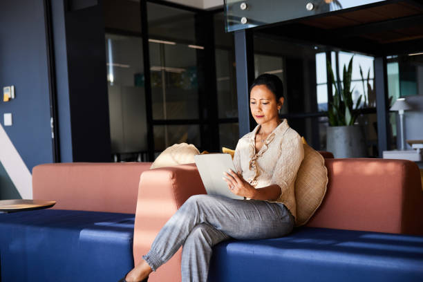 istock Mature businesswoman working on a tablet on an office sofa 1410828695