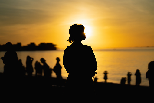silhouette of a woman at sunrise by the sea