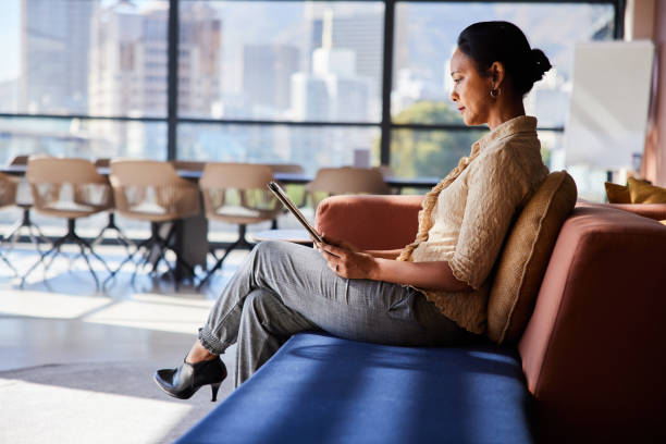 istock Mature businesswoman using a tablet while sitting on an office sofa 1410828845