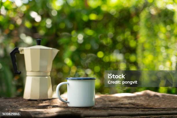 Hot Coffee In A White Enamel Mug On An Old Wooden Floor While Camping In The Forest Soft Focusshallow Focus Effect Stock Photo - Download Image Now
