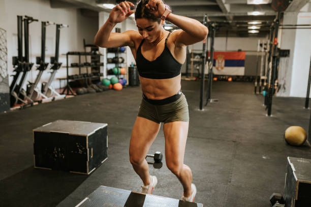 istock Strong young woman doing box jump exercise during training 1410833314