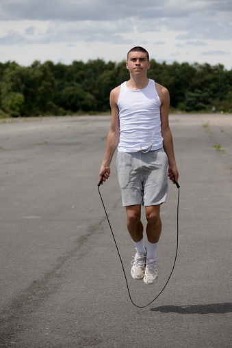A Nineteen Year Old Teenage Boy Using A Skipping Rope in A Public Park