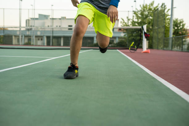boy is running at tennis court focus on foreground horizontal photo stock photo