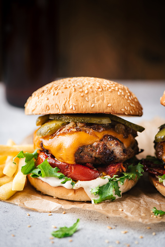 Juicy Craft Cheeseburger With Roasted Bell Pepper On Parchment Paper, Closeup View