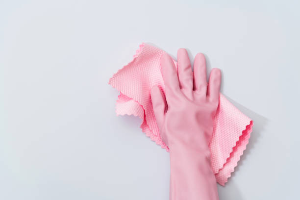 Woman hand cleaning white wall with rag.