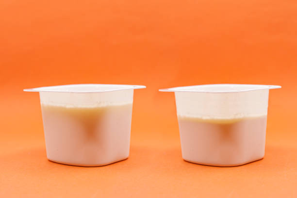 Yogurt less full than the previous one. Shrinkflation concept Yogurt less full than the previous one. Shrinkflation is the reduction in the size of a product in response to rising production costs or market competition consumer confidence photos stock pictures, royalty-free photos & images