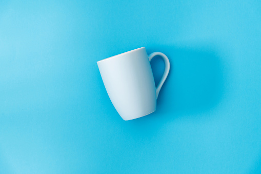 White mug on blue background.
