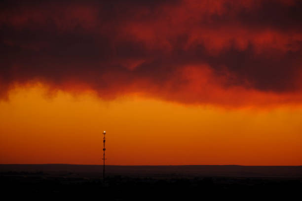 Silhouette of cell tower at sunset on skyline for digital communication