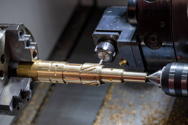 The multi-tasking CNC lathe machine  groove cutting the brass shaft parts by milling spindle. stock photo