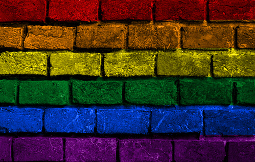 Rainbow flag over old brick wall
