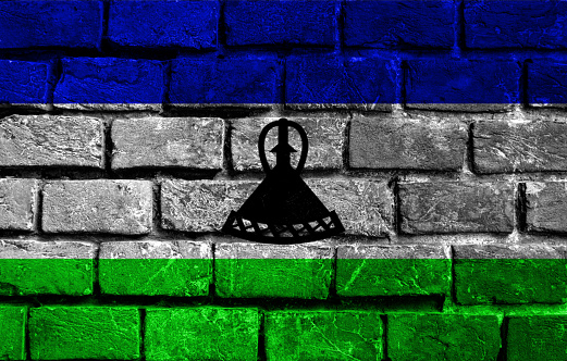 Flag of Lesotho on old grunge wall in background