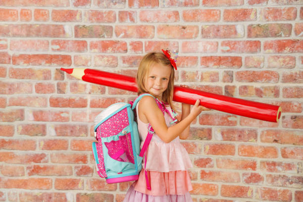 赤いペンを持つ小さな幸せな子供、最初の学校の日に学ぶ準備ができています - school supplies child back to school book ストックフォトと画像
