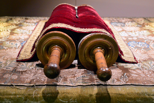 Rolled up Torah scrolls and yad ritual pointer, set on a the desk of a bimah / tivah, the platform used by the hazzan for Torah readings