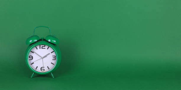 istock green alarm clock on a green background 1410860479