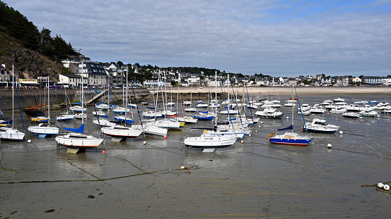 Erquy, France, July 7, 2022 - Ships and sailboats in the port of Erquy at low tide