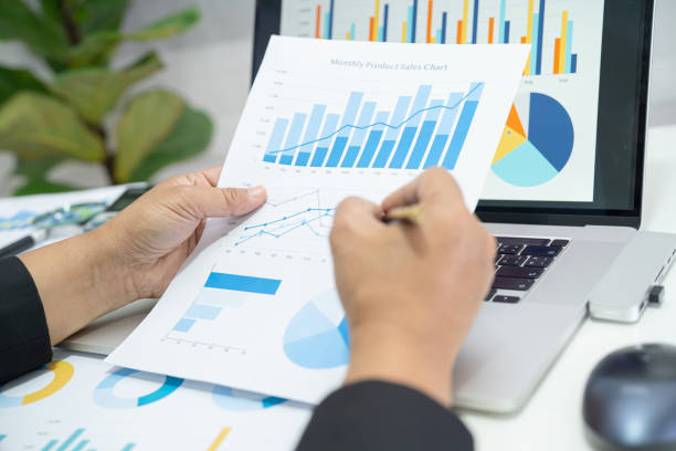 istock Asian accountant working and analyzing financial reports project accounting with chart graph in modern office, finance and business concept. 1410860614