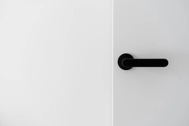 istock Black metal handle on white minimalist door 1410861385
