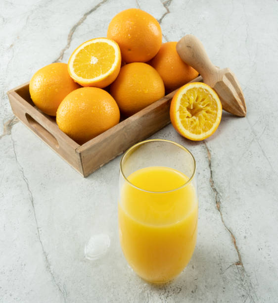 istock Fresh ripe oranges and juice on white marble stone background. side view, squeezed. 1410862261