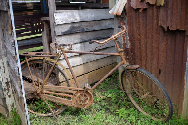 un vieux vélo très rouillé était garé dans un coin - bicycle broken old chain photos et images de collection