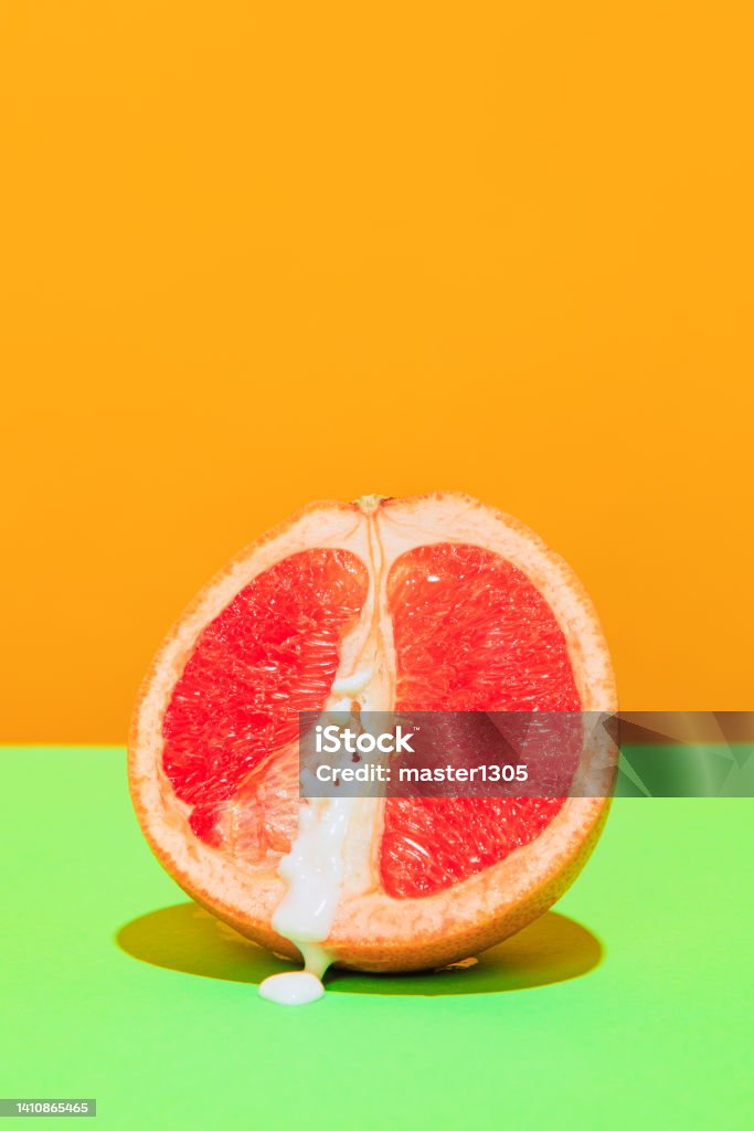 Image of juicy grapefruit isolated on green orange background Food pop art photography. Image of juicy grapefruit isolated on green orange background. Sweet and sour taste. Vintage, retro style. Complementary colors, Copy space for ad, text Old-fashioned Stock Photo