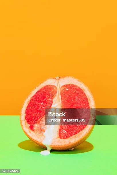 Image Of Juicy Grapefruit Isolated On Green Orange Background Stock Photo - Download Image Now