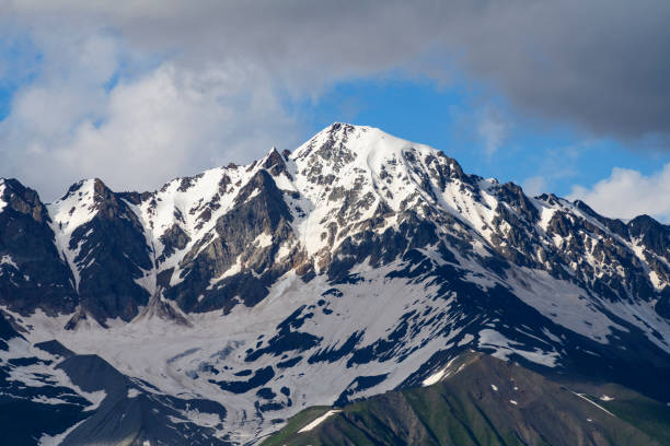 istock Beautiful snow covered mountains with in the fog and dramatic clouds. 1410869893