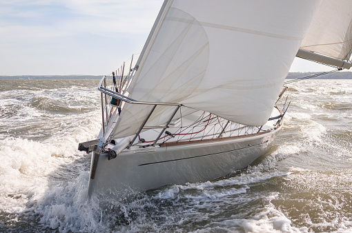 Close up of sailing boat, sail boat or yacht on a rough sea with white sails